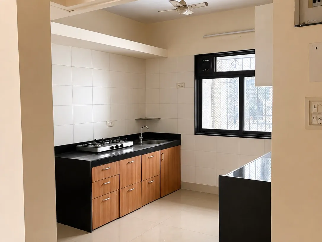 Modular kitchen with black countertop in a Chembur flat for rent